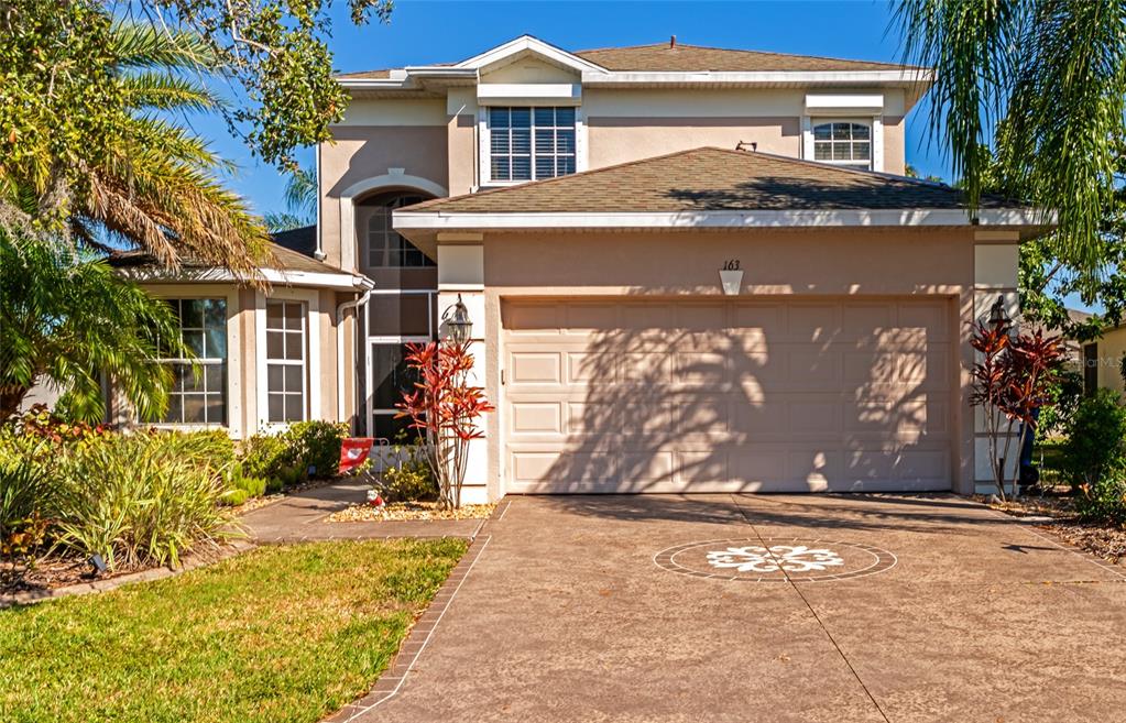 a front view of a house with a yard and a garage