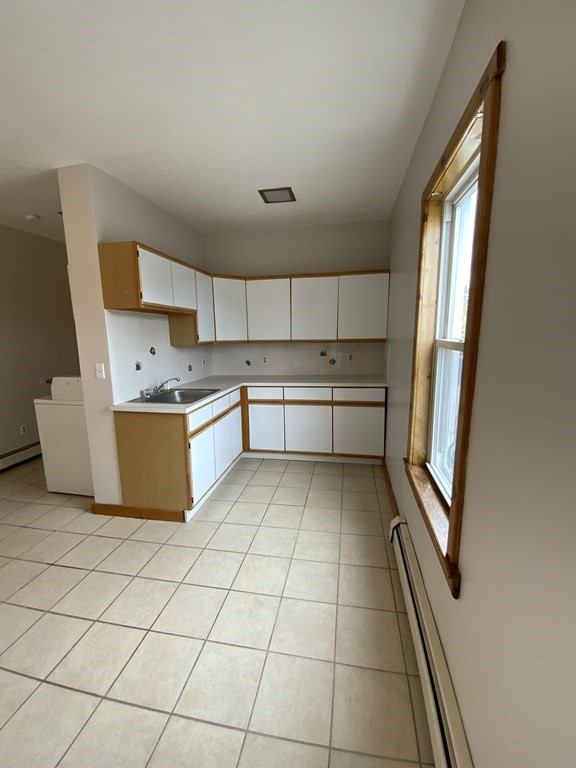 a kitchen with stainless steel appliances a sink a stove a refrigerator and cabinets