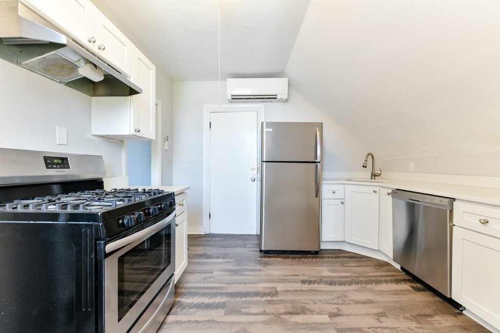 a kitchen with a stove top oven a refrigerator and a cabinets