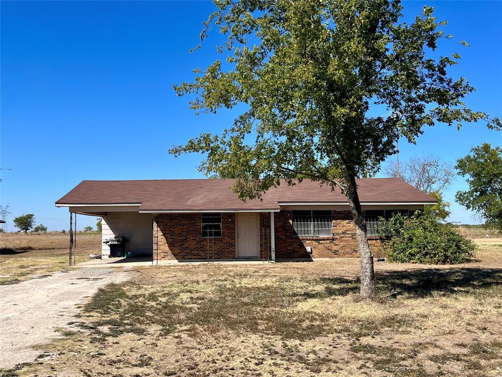 a front view of a house with a tree