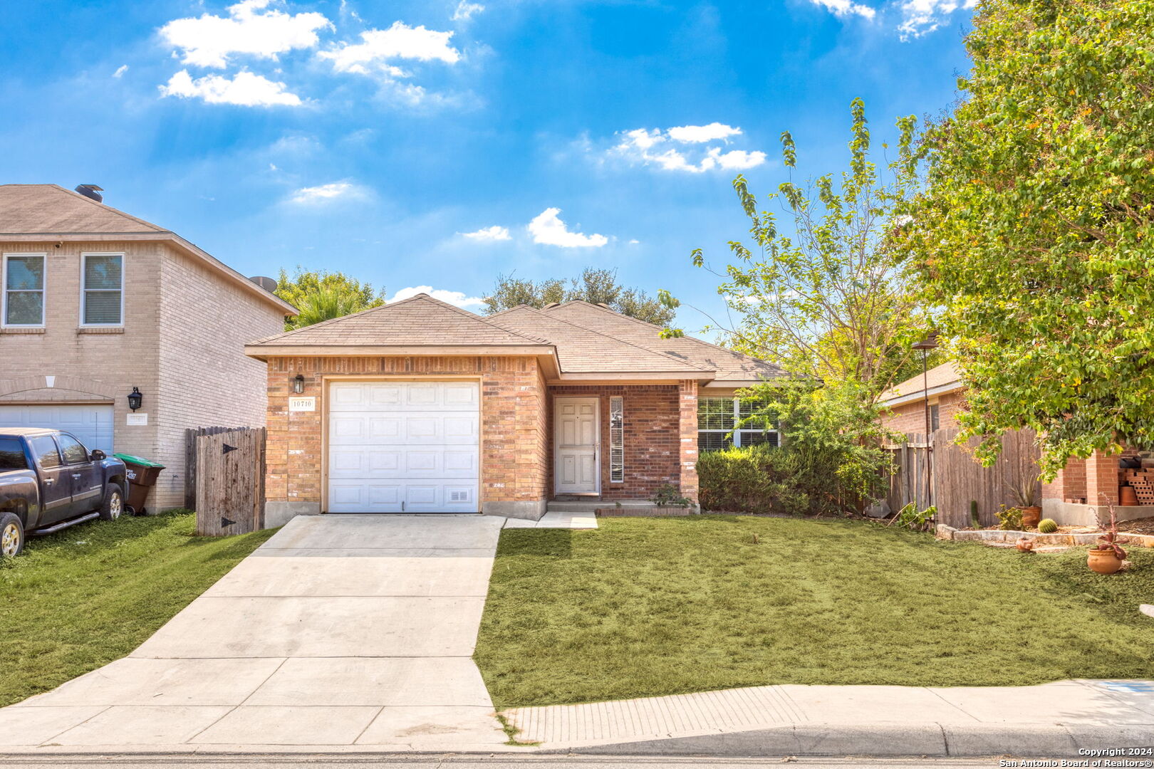 a front view of a house with a yard and potted plants