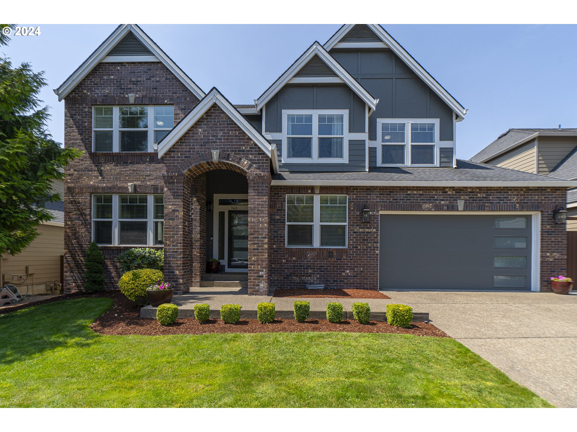 a front view of a house with a yard and garage