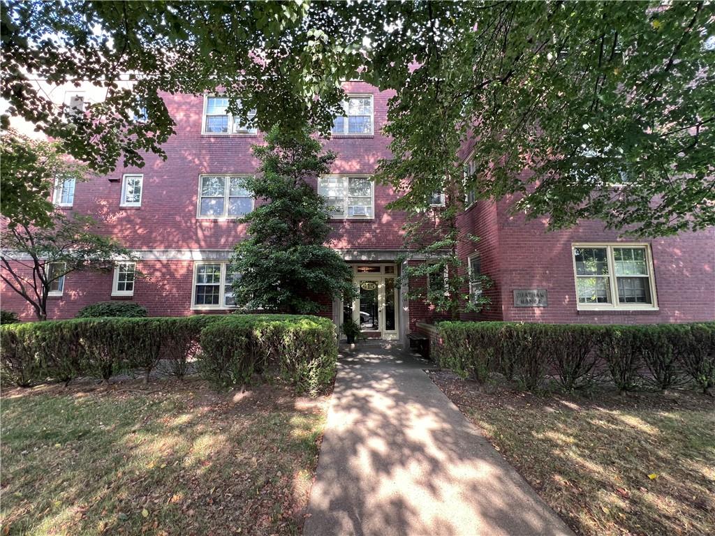 a front view of a house with a yard and tree s