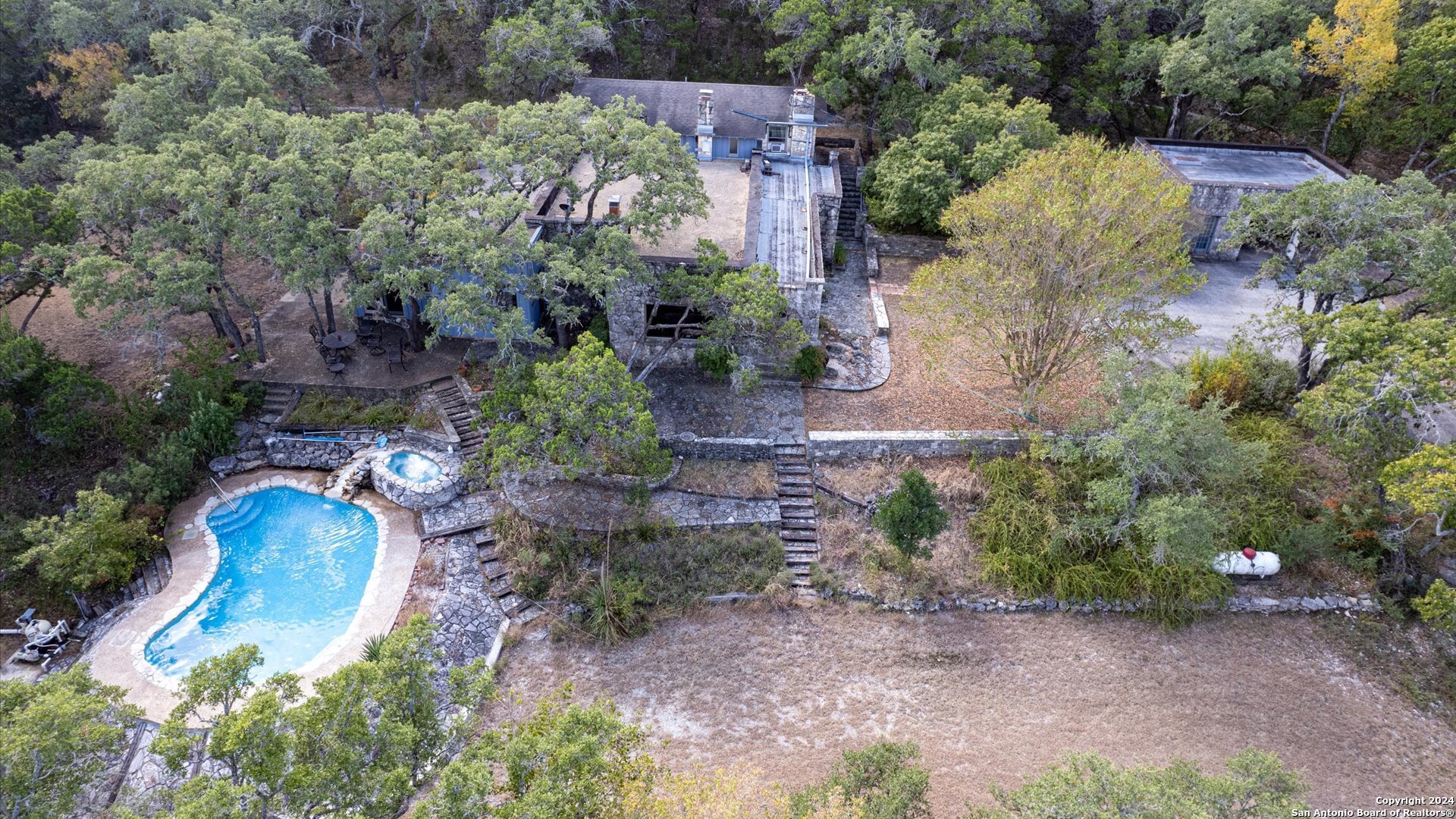 a aerial view of a house with a yard and greenery