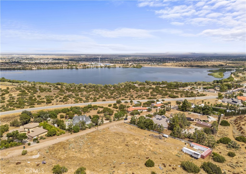 an aerial view of ocean and residential houses with outdoor space