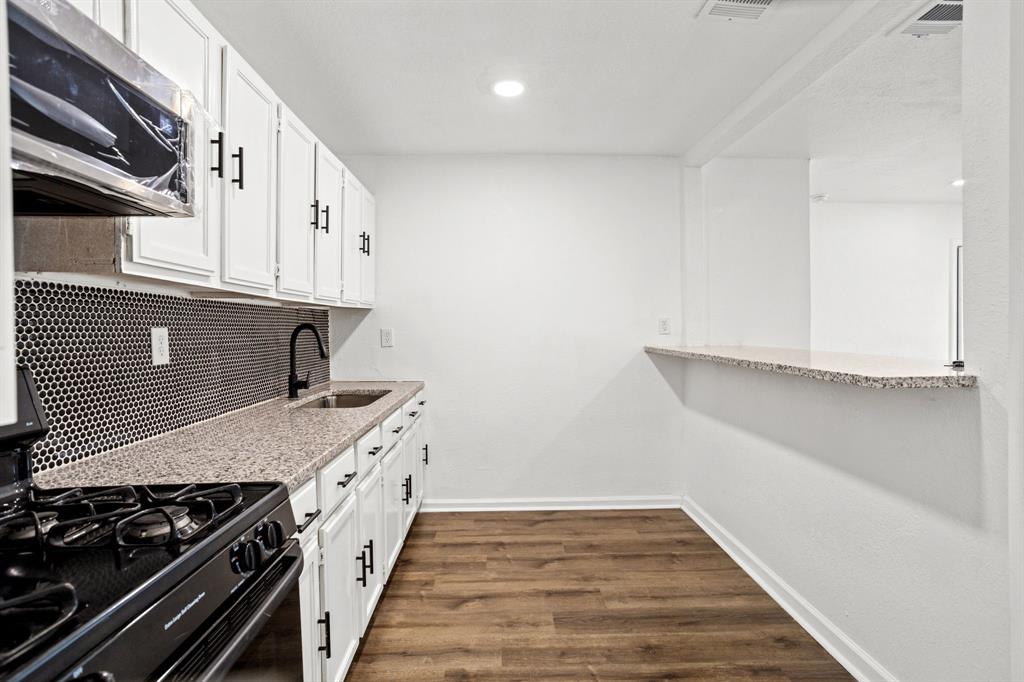 a kitchen with granite countertop a stove and a cabinets