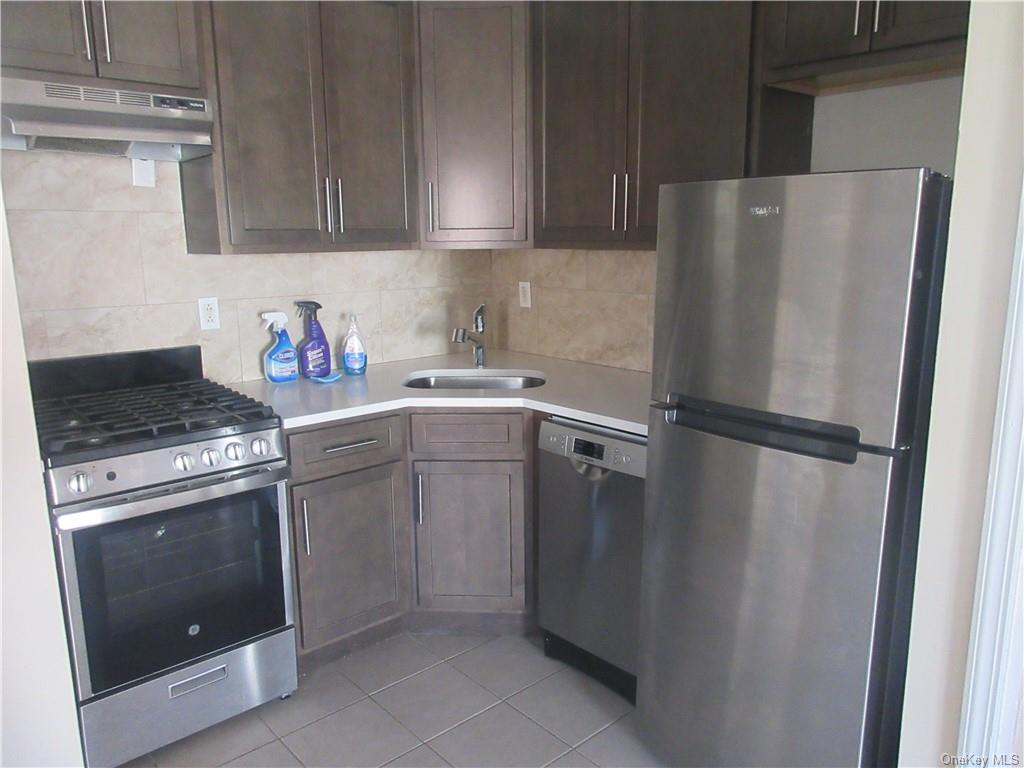 a kitchen with a refrigerator sink stove and cabinets