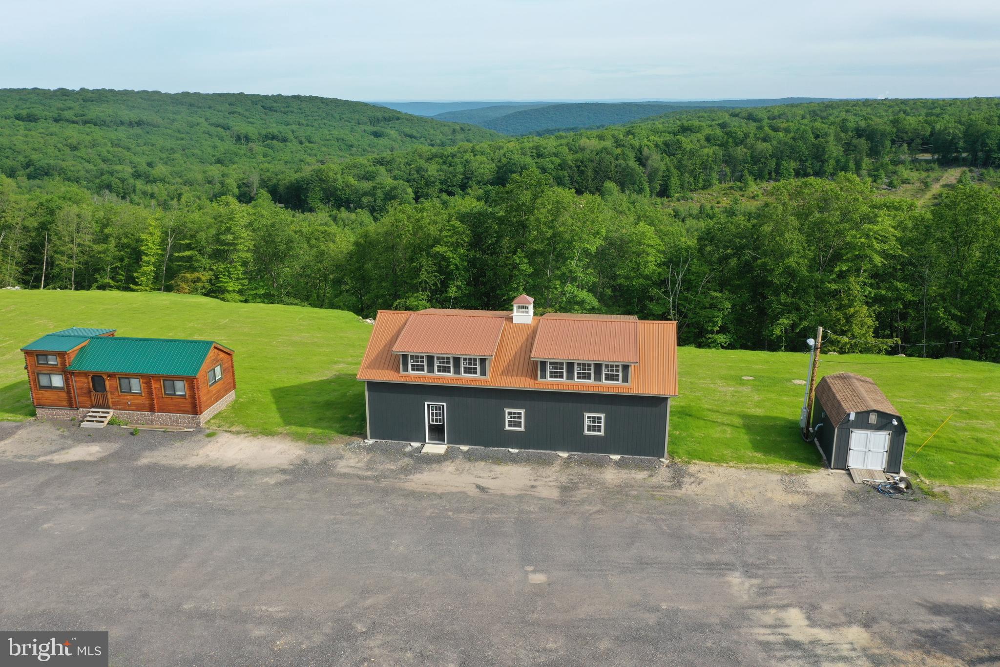 an aerial view of a house with pool and a yard