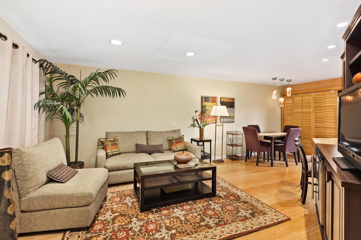 a living room with furniture kitchen view and a large window