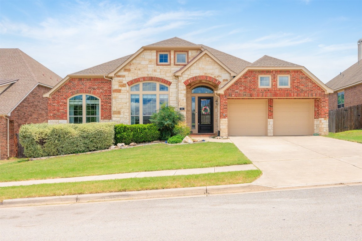 a front view of a house with a garden and garage