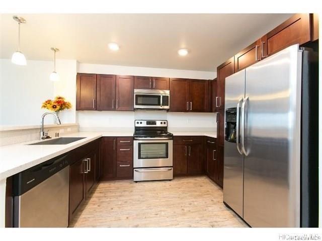 a kitchen with kitchen island a counter top space cabinets and stainless steel appliances