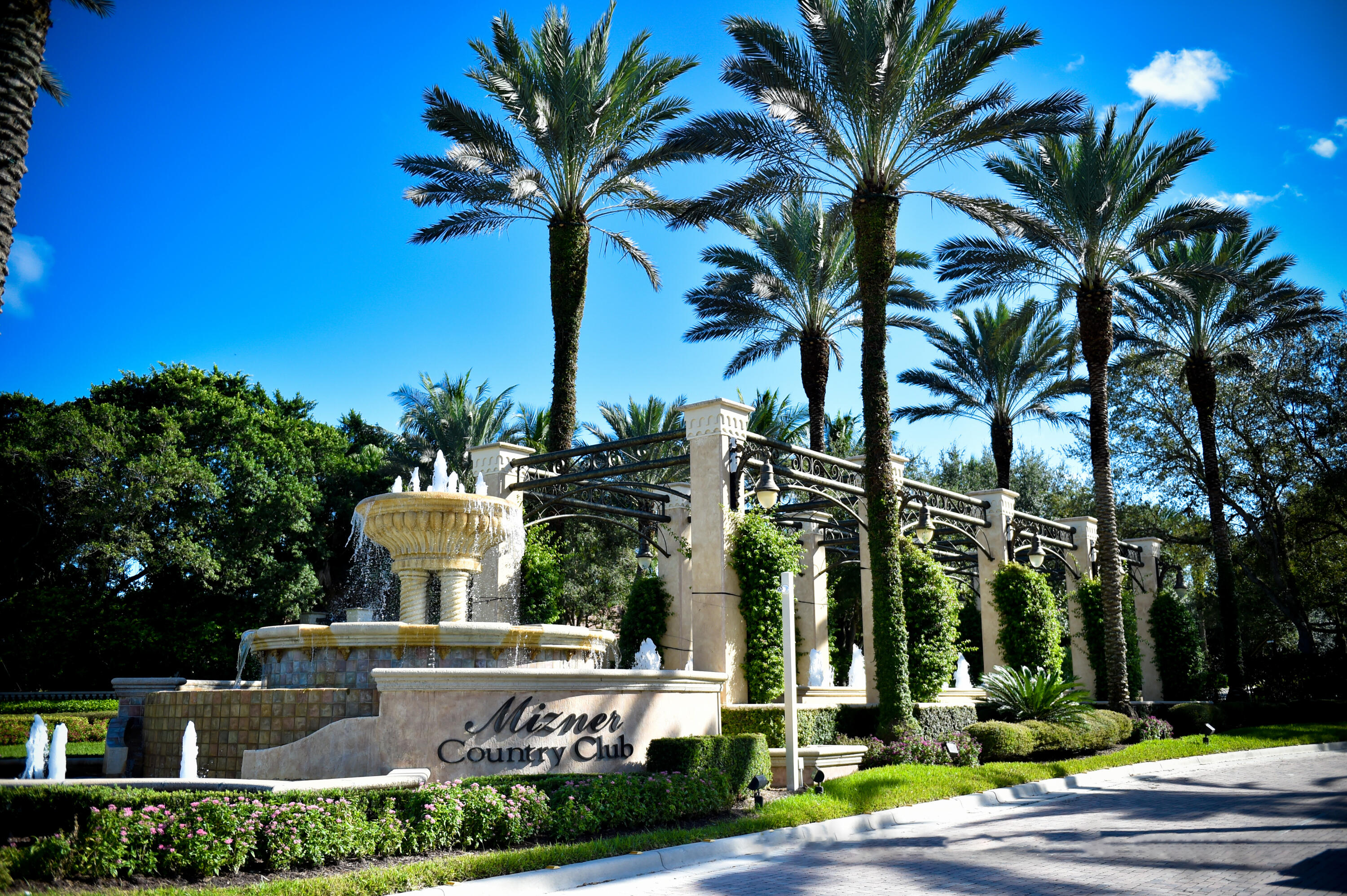 a view of a house with a yard and palm trees