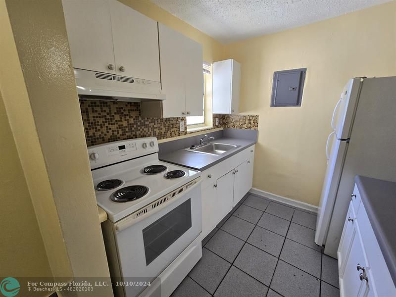 a kitchen with a stove a sink and a refrigerator