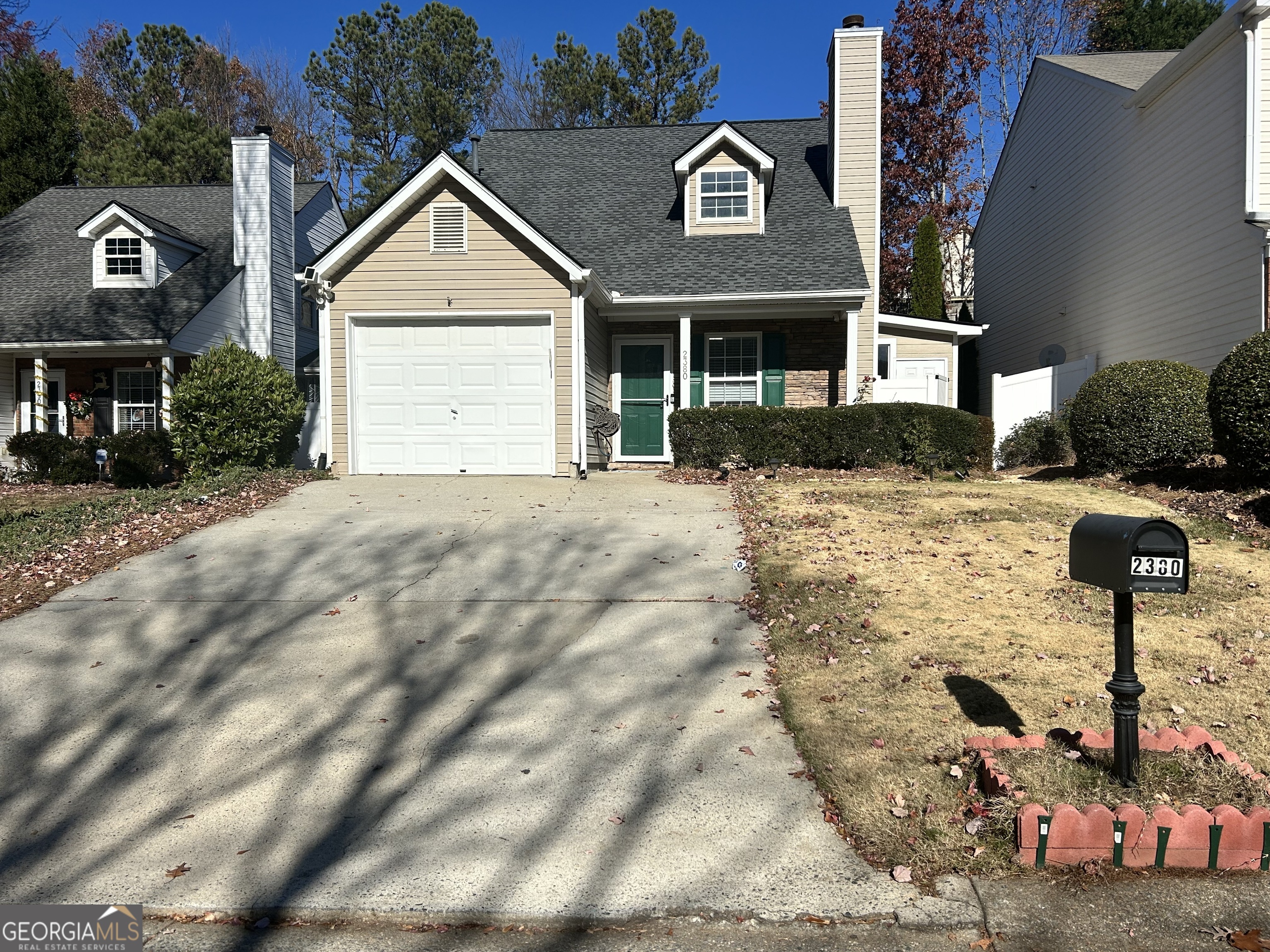 a view of a brick house with many windows next to a road