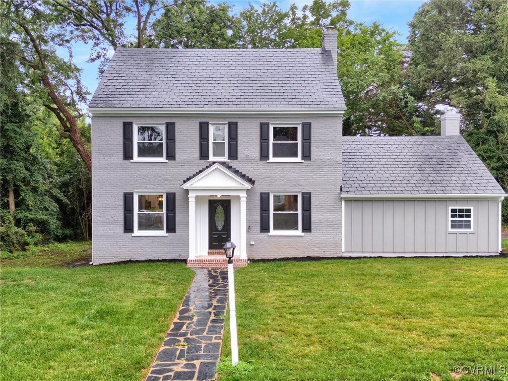 a front view of a house with a garden and yard