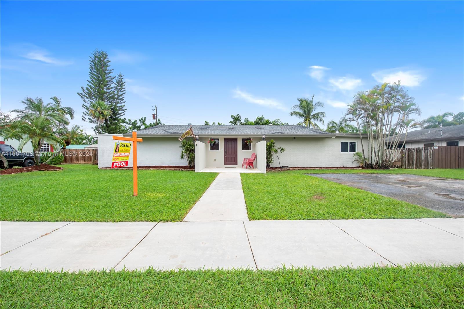 a front view of a house with a yard and trees