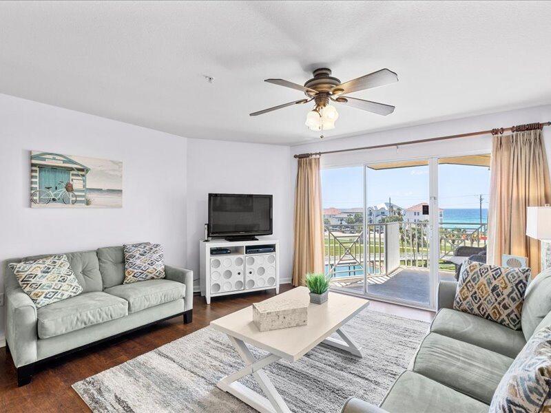 a living room with furniture a flat screen tv and a large window