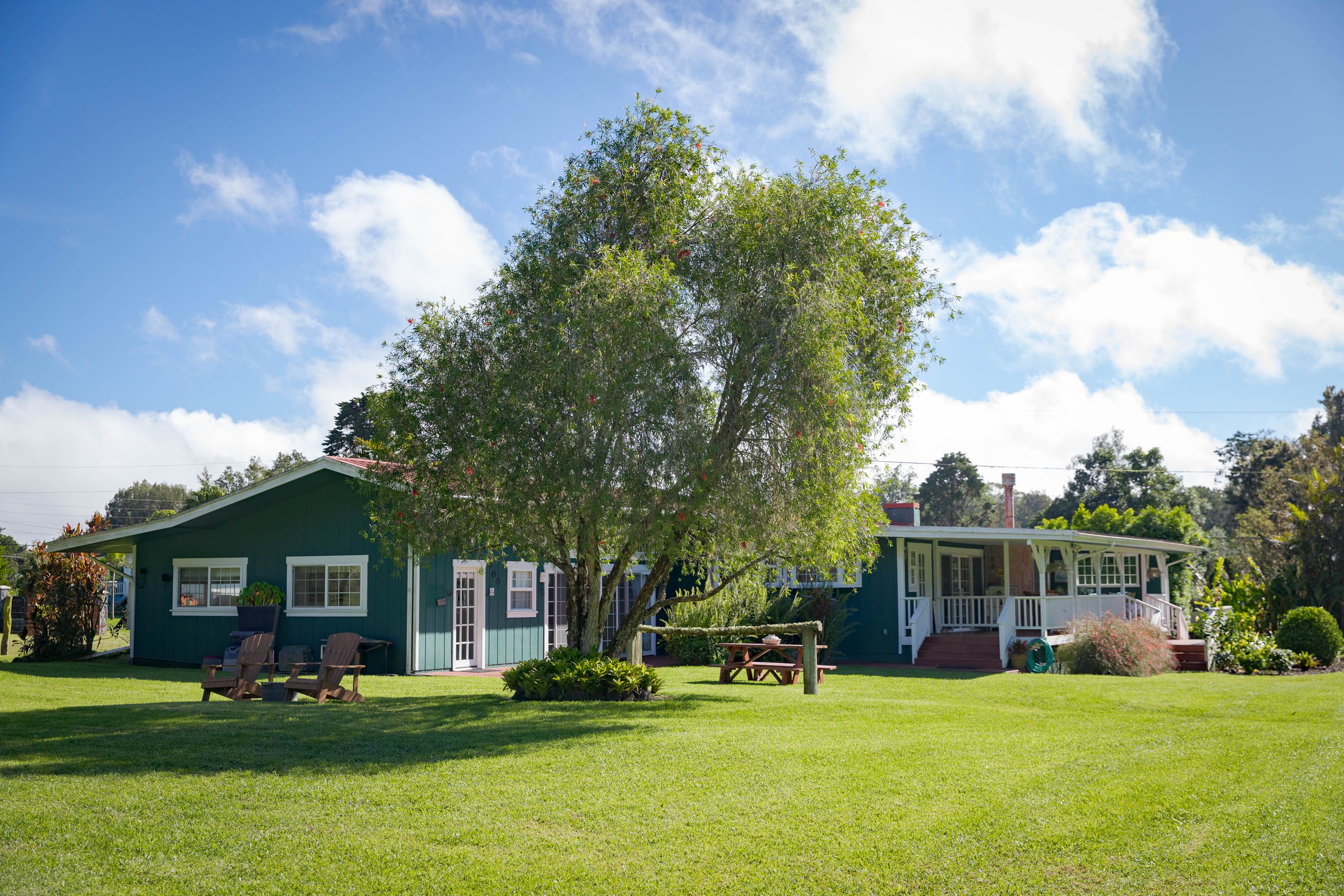 a front view of a house with a garden and trees