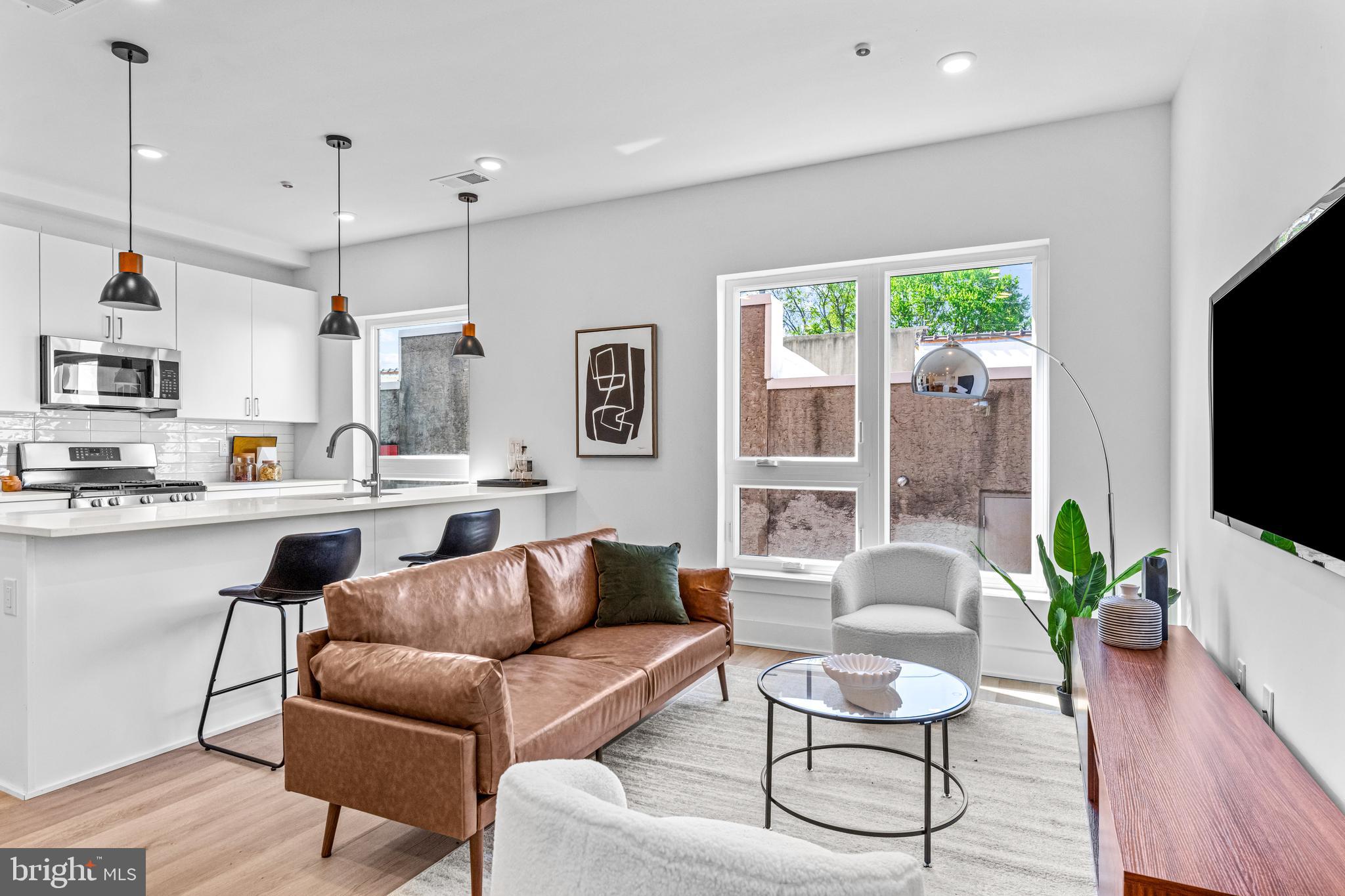 a living room with furniture kitchen and a flat screen tv