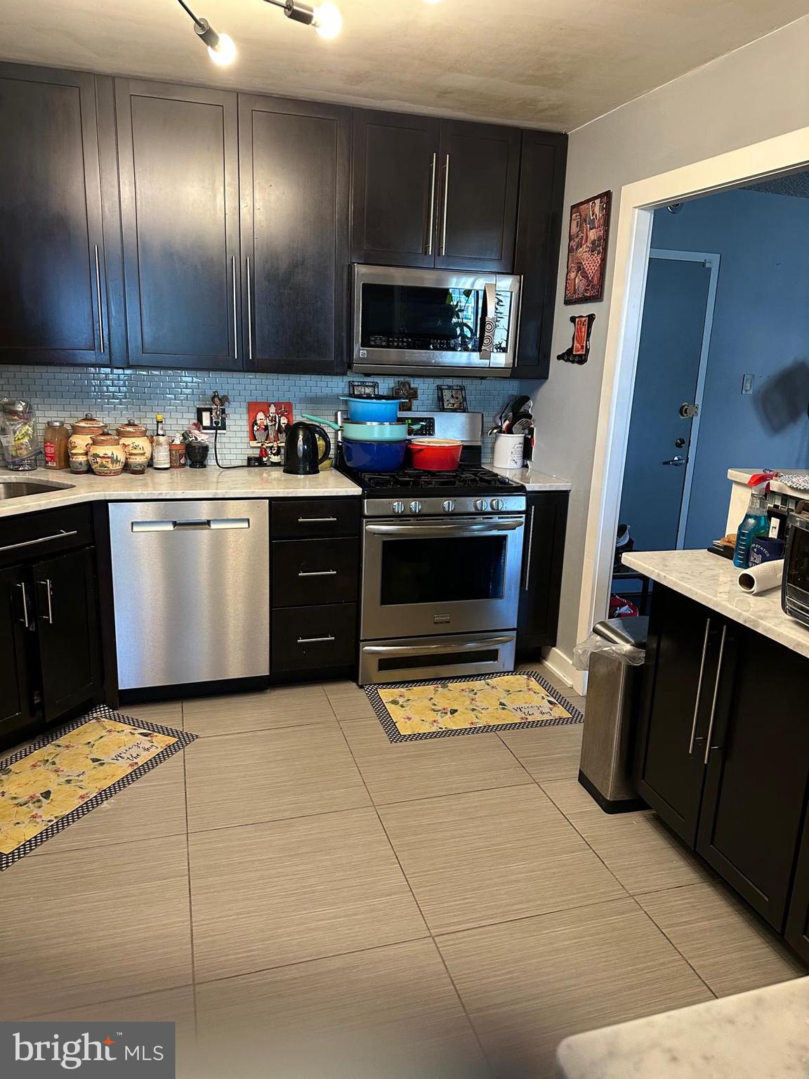 a kitchen with a refrigerator and a stove top oven