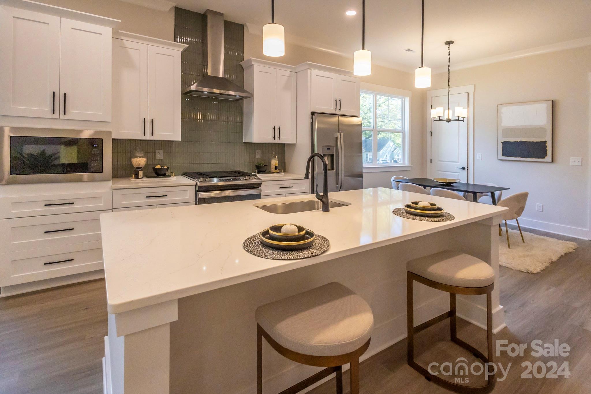 a kitchen with a sink a stove and chairs