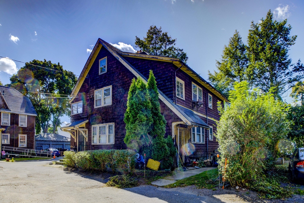 a front view of a house with a yard and potted plants