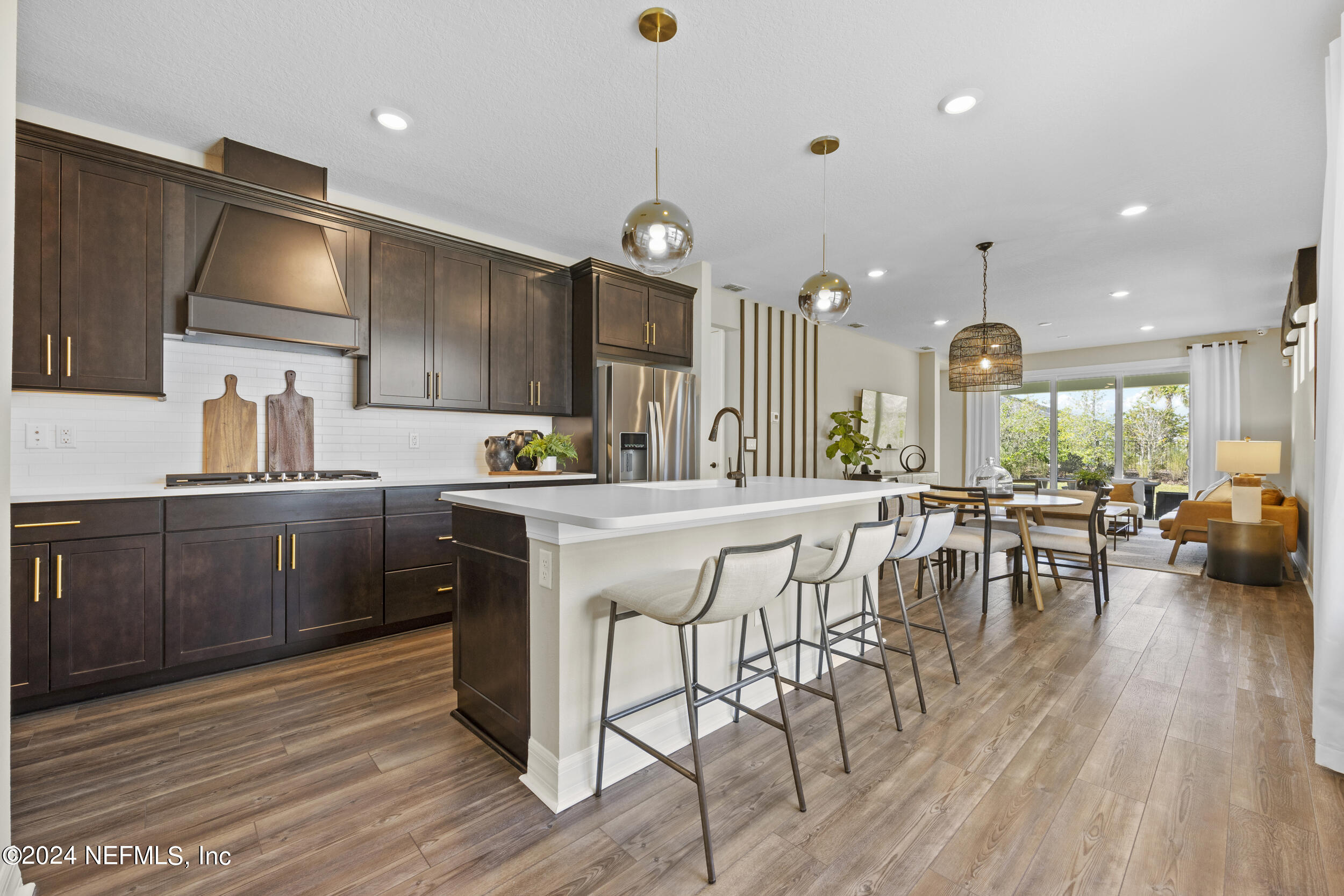 a kitchen with a table chairs refrigerator and cabinets