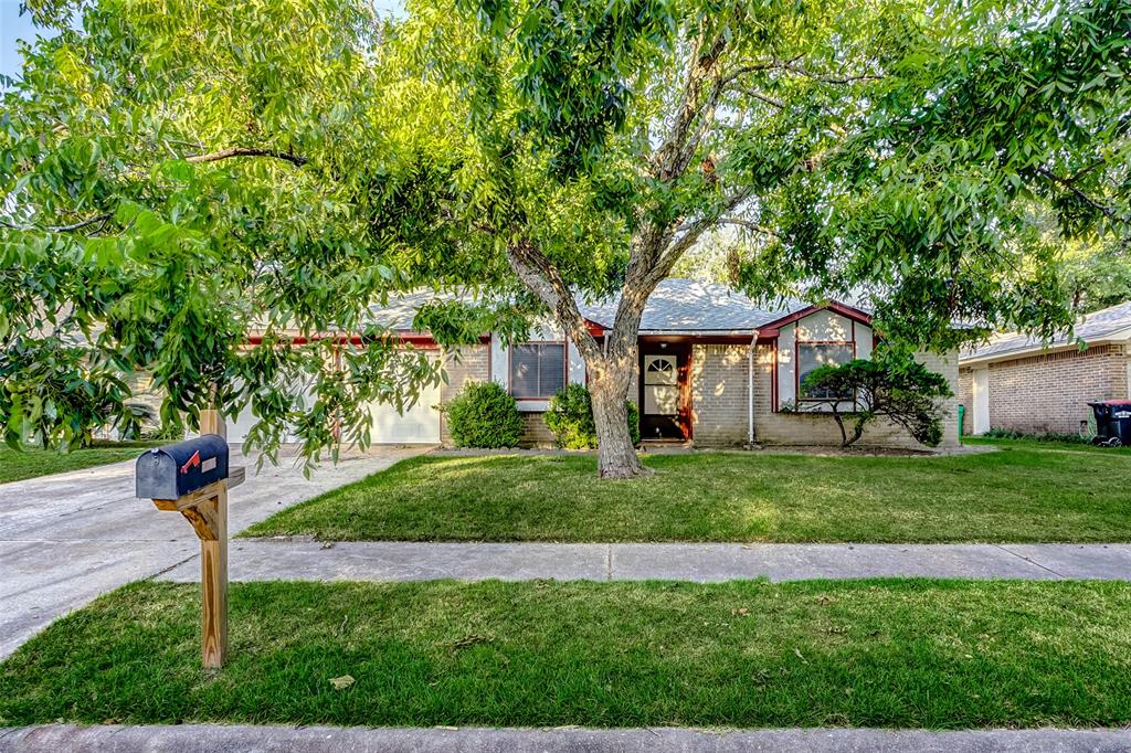 a front view of a house with a yard and trees