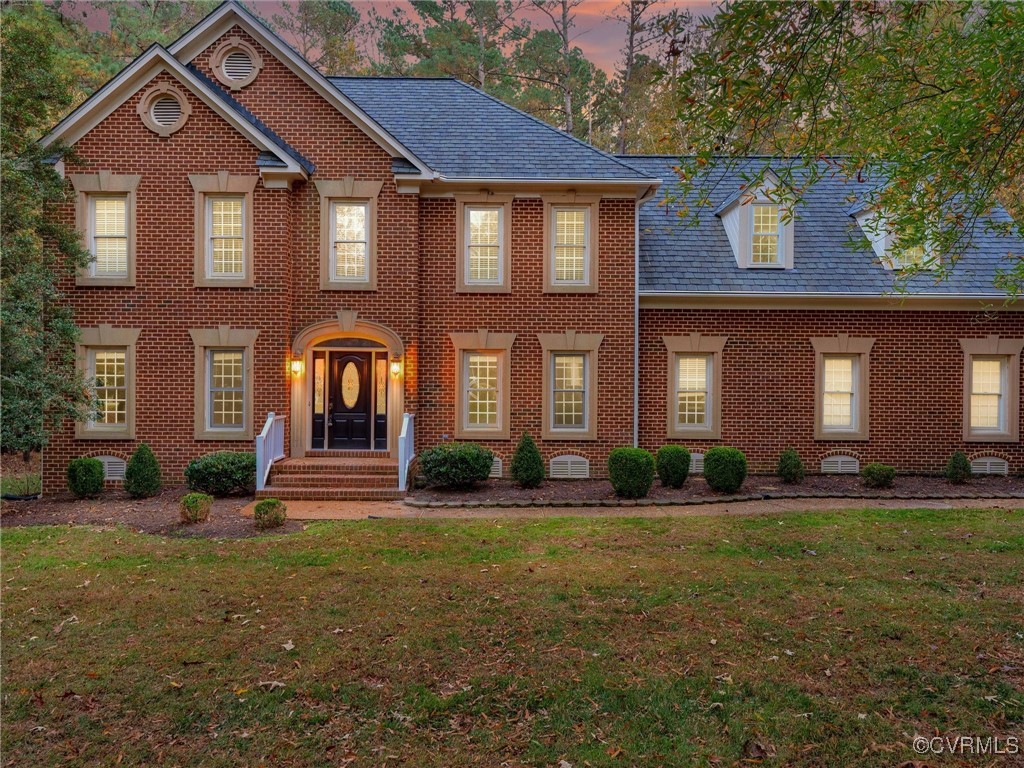 Colonial-style house with a lawn