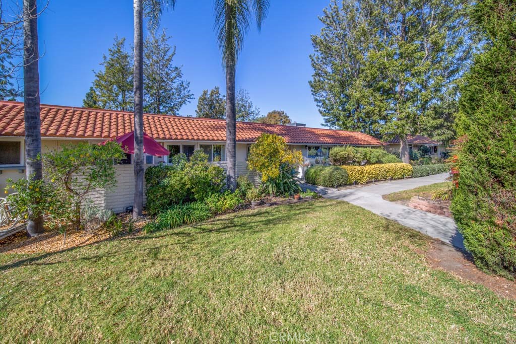 a view of a house with a yard and potted plants