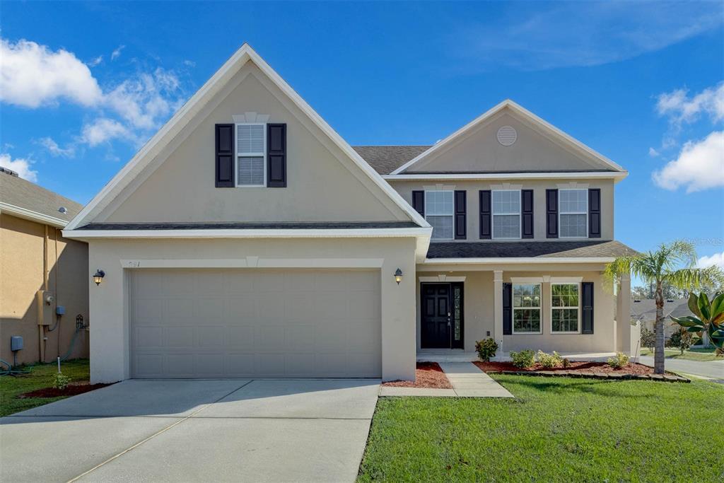 a front view of a house with a yard and garage