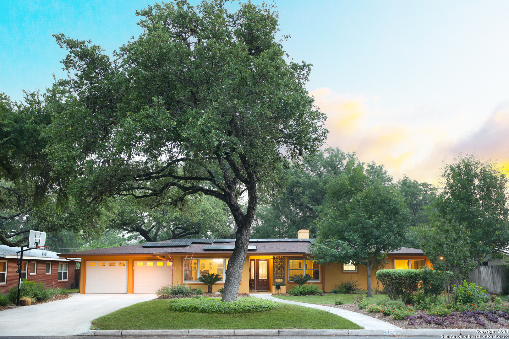 a front view of a house with a yard and trees