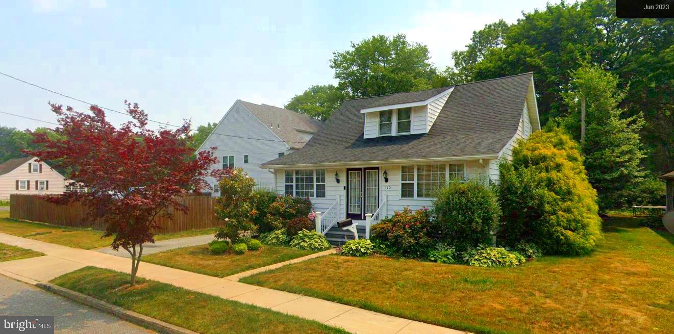 a front view of house with yard and trees around