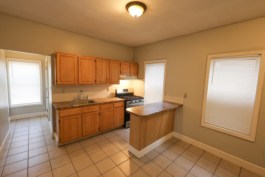 a kitchen with stainless steel appliances granite countertop a sink and a stove