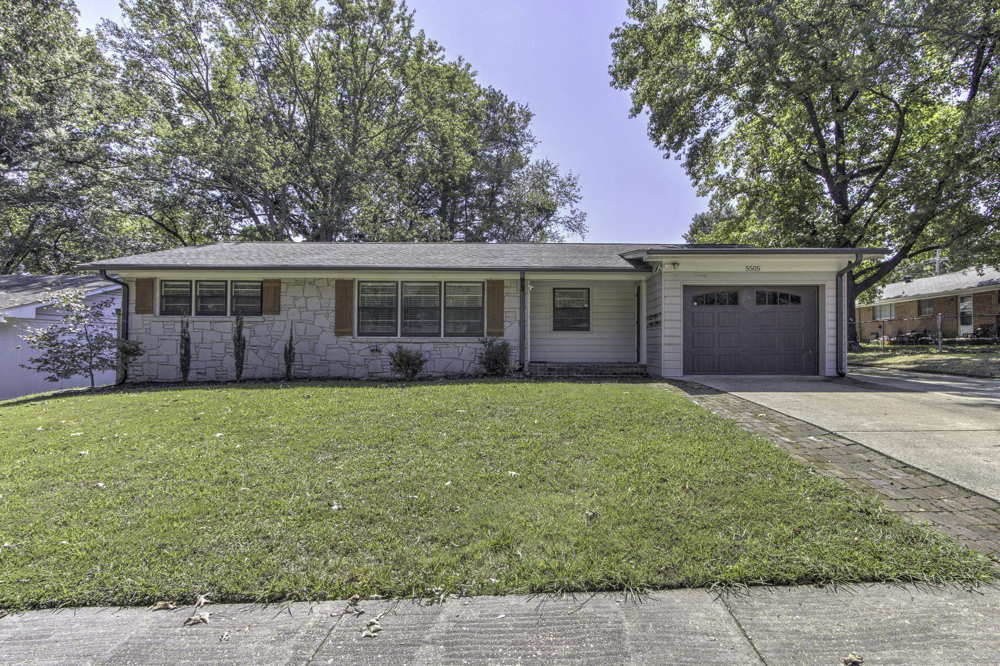 a view of a house with a backyard and a tree