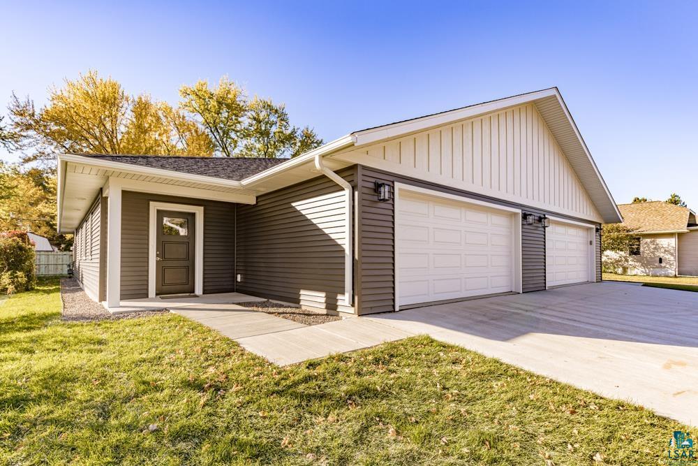 Ranch-style house featuring a front yard and a garage