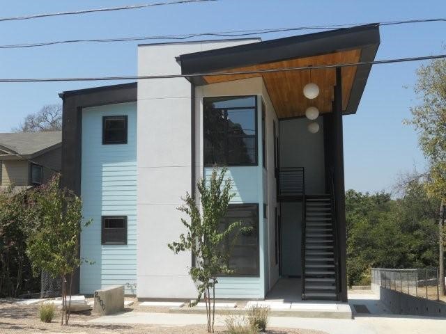 a front view of a house with a tree