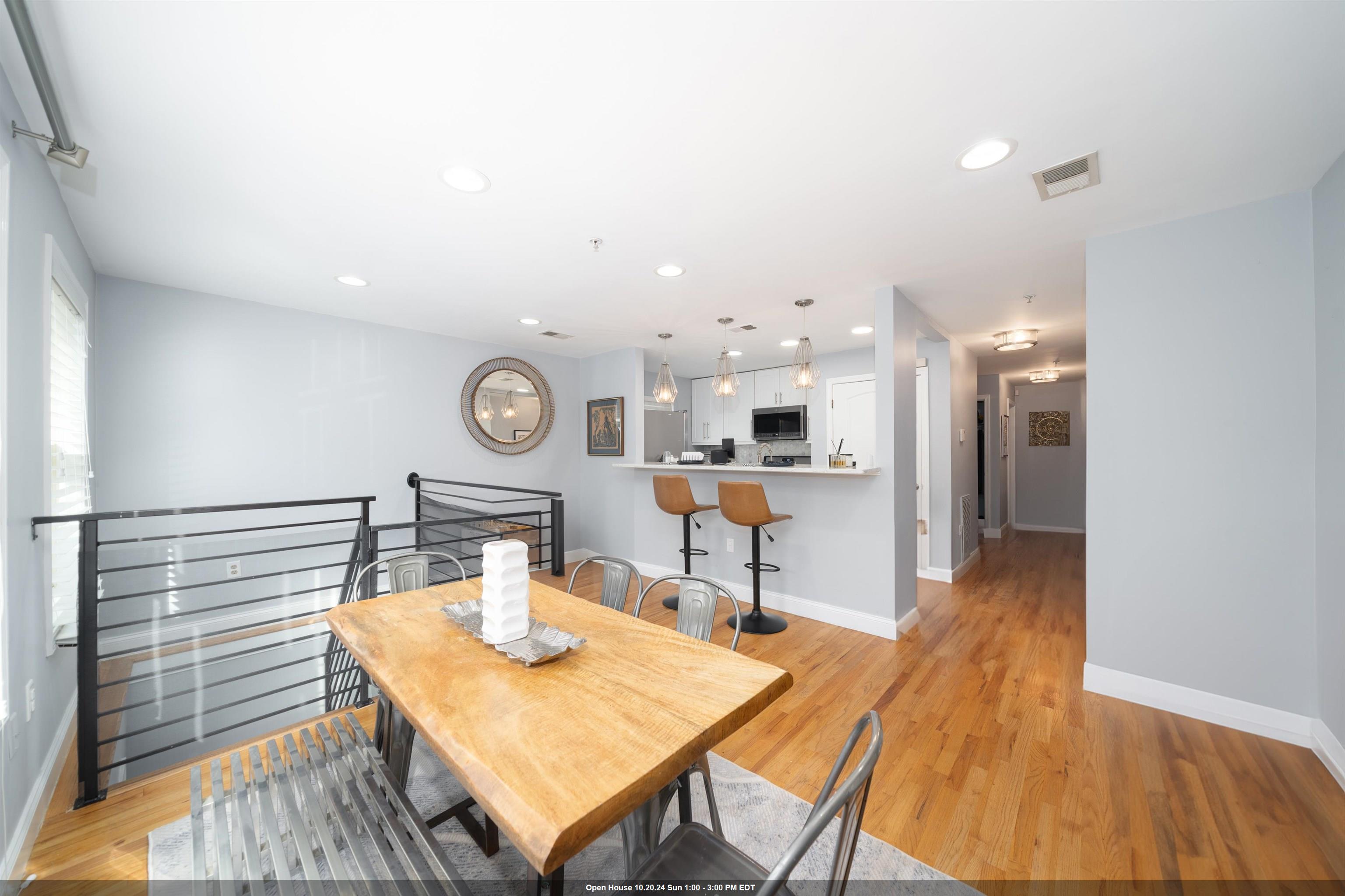 a living room with kitchen island a table and chairs in it