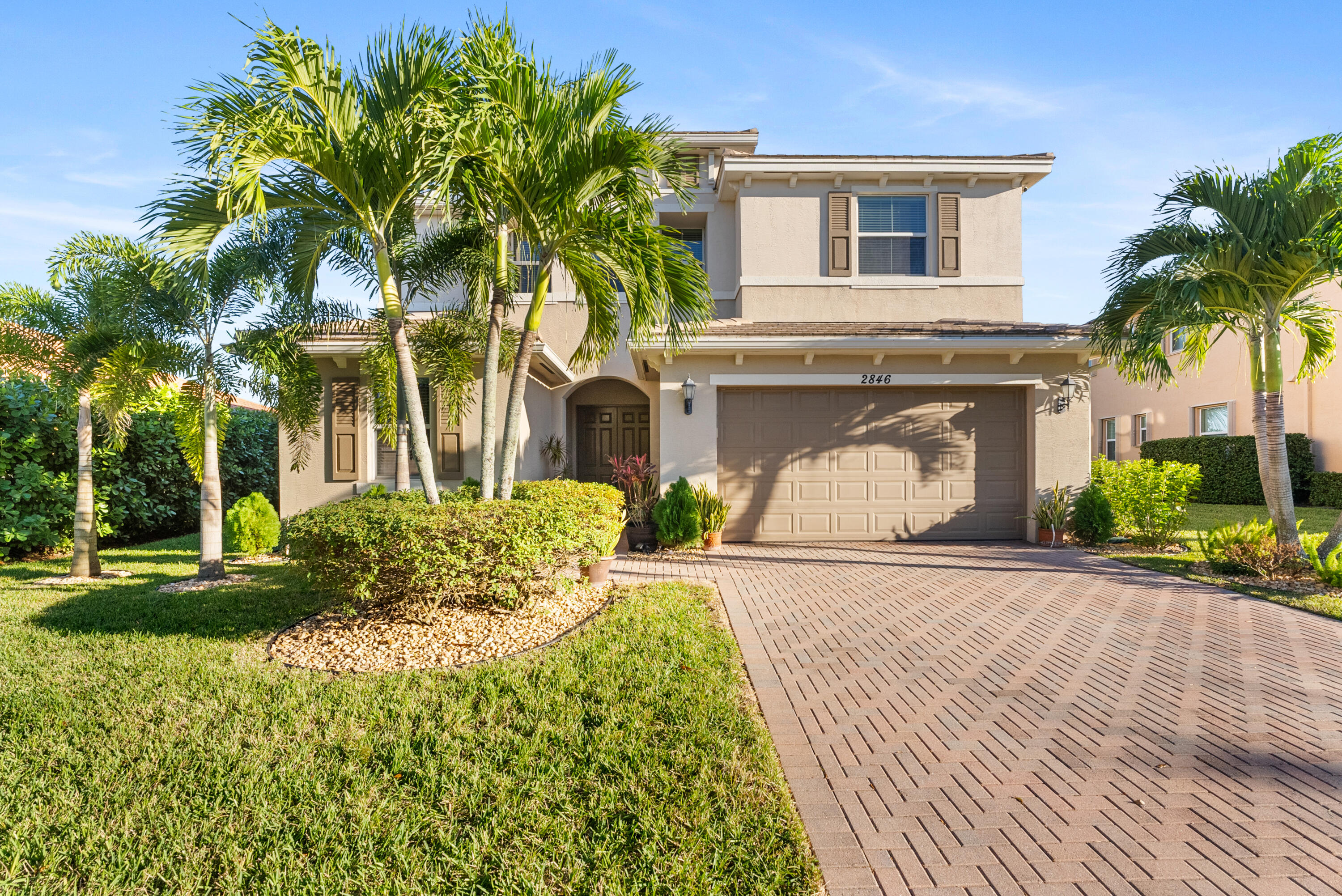 a front view of a house with a yard and potted plants