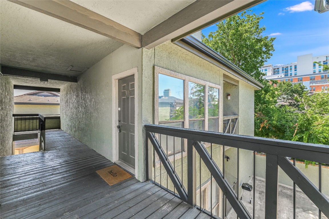 a view of a balcony with wooden floor and fence