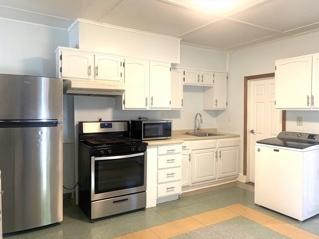 a kitchen with stainless steel appliances a stove a sink and a refrigerator