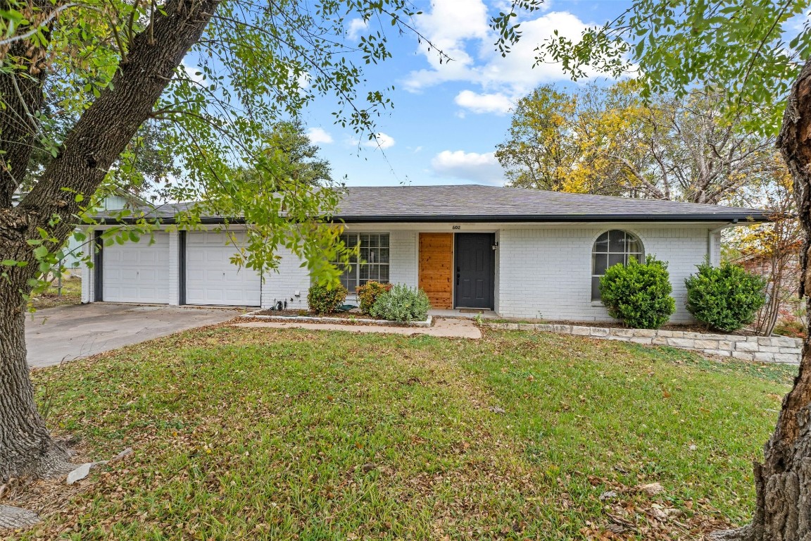 a front view of house with yard and trees around