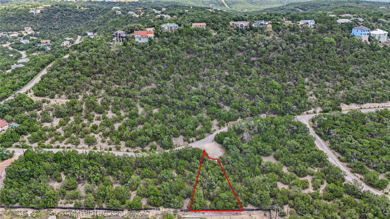 an aerial view of residential house with outdoor space and trees all around