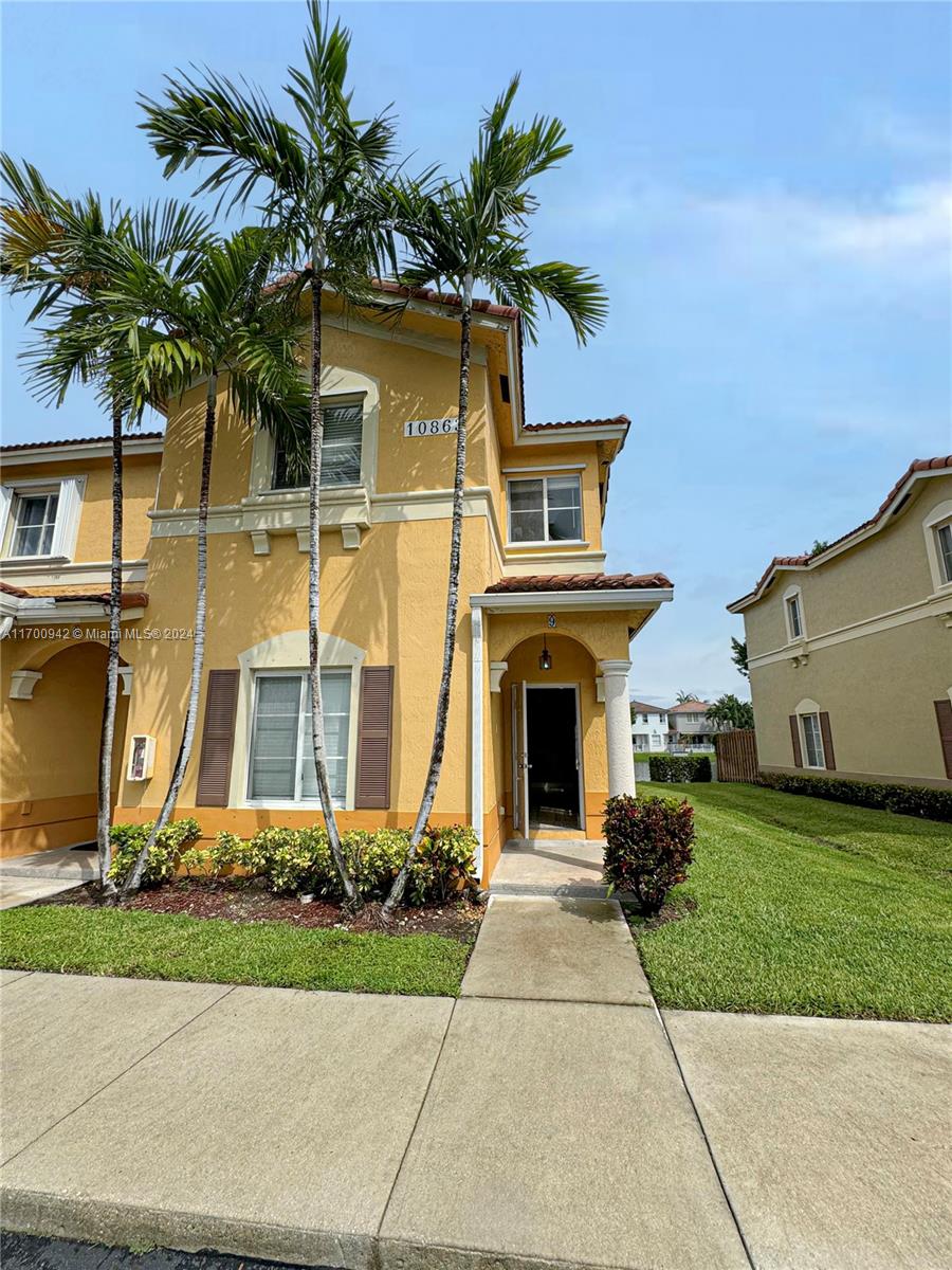 a front view of a house with yard and parking