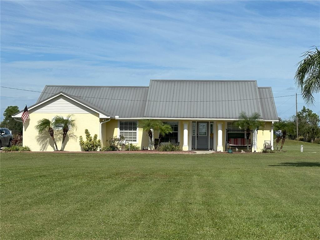 a view of house with yard and outdoor seating