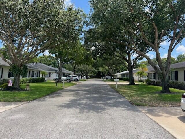 a view of a house with a big yard and large trees