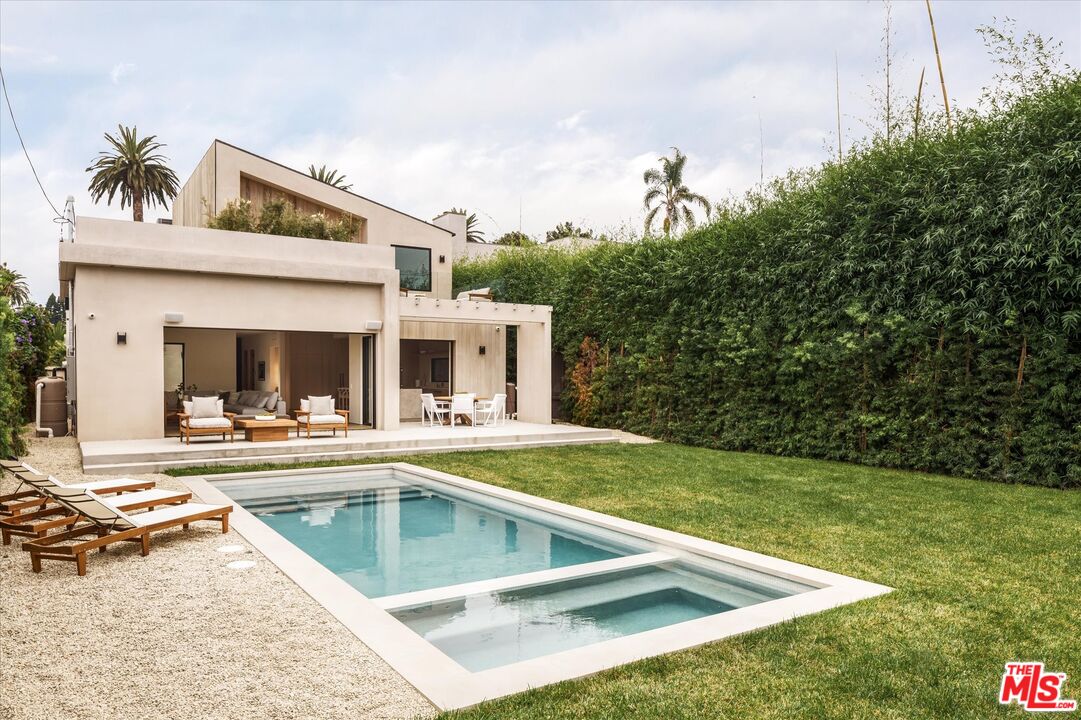 a view of a house with swimming pool and sitting area