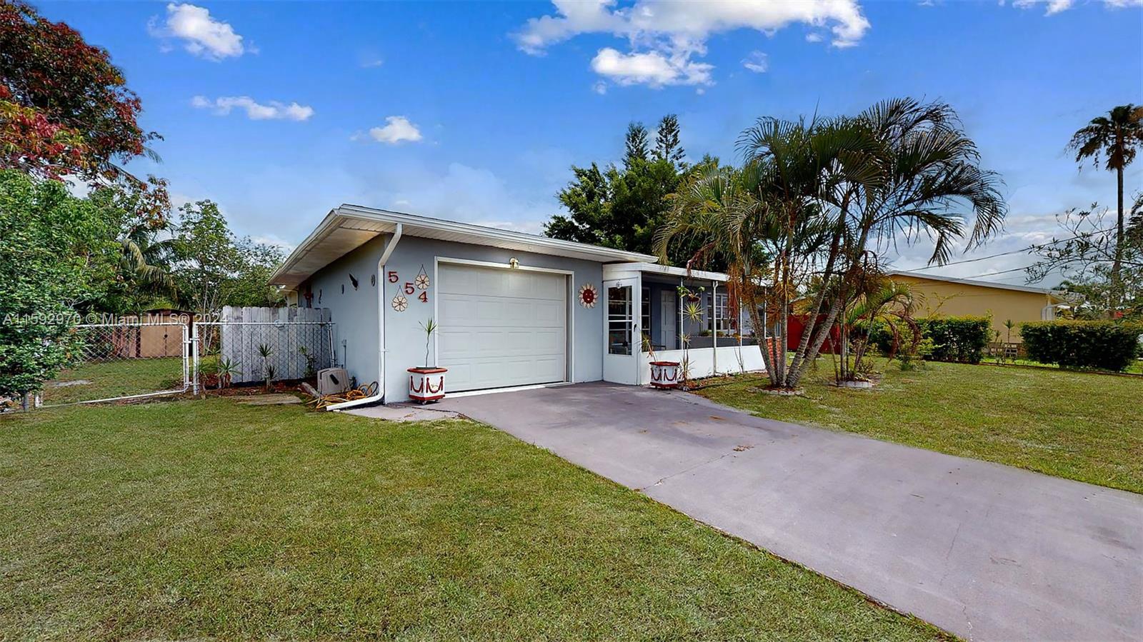 a view of a house with backyard and a tree