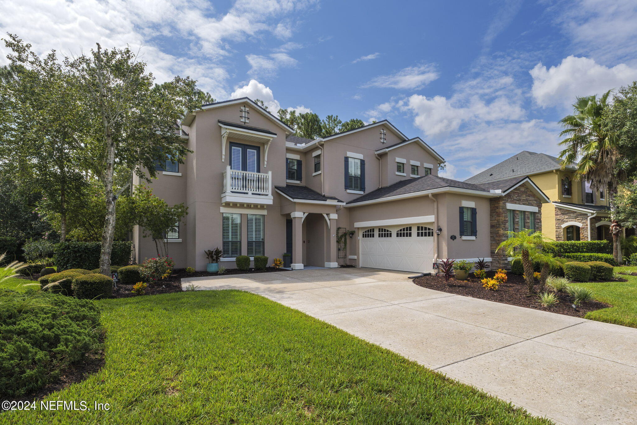 a front view of a house with a garden and plants