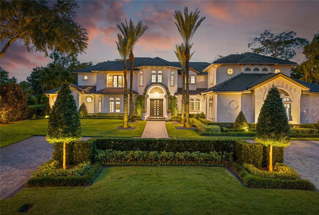 a front view of a house with garden and swimming pool